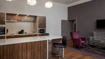A modern kitchen with wooden cabinets, a bar area, and pendant lighting.