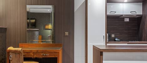 Un baño moderno con tocador de madera, un espejo y zona de ducha.