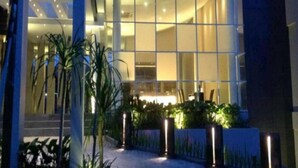 Un bâtiment moderne doté de grandes fenêtres, d’une façade incurvée et d’une entrée bien éclairée.
