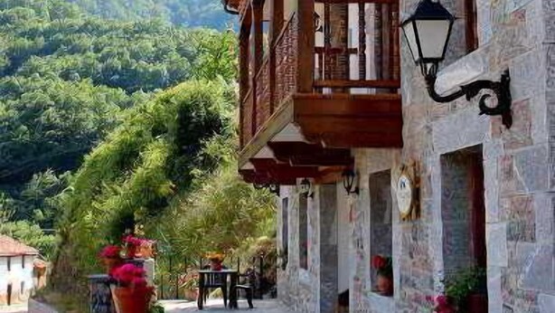 Un edificio de piedra con balcones de madera y un sendero de piedra.