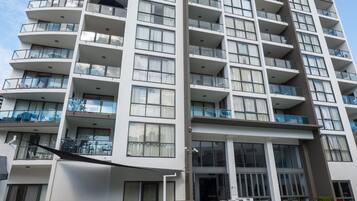 A high-rise hotel with multiple balconies, a swimming pool, and a modern architectural design.