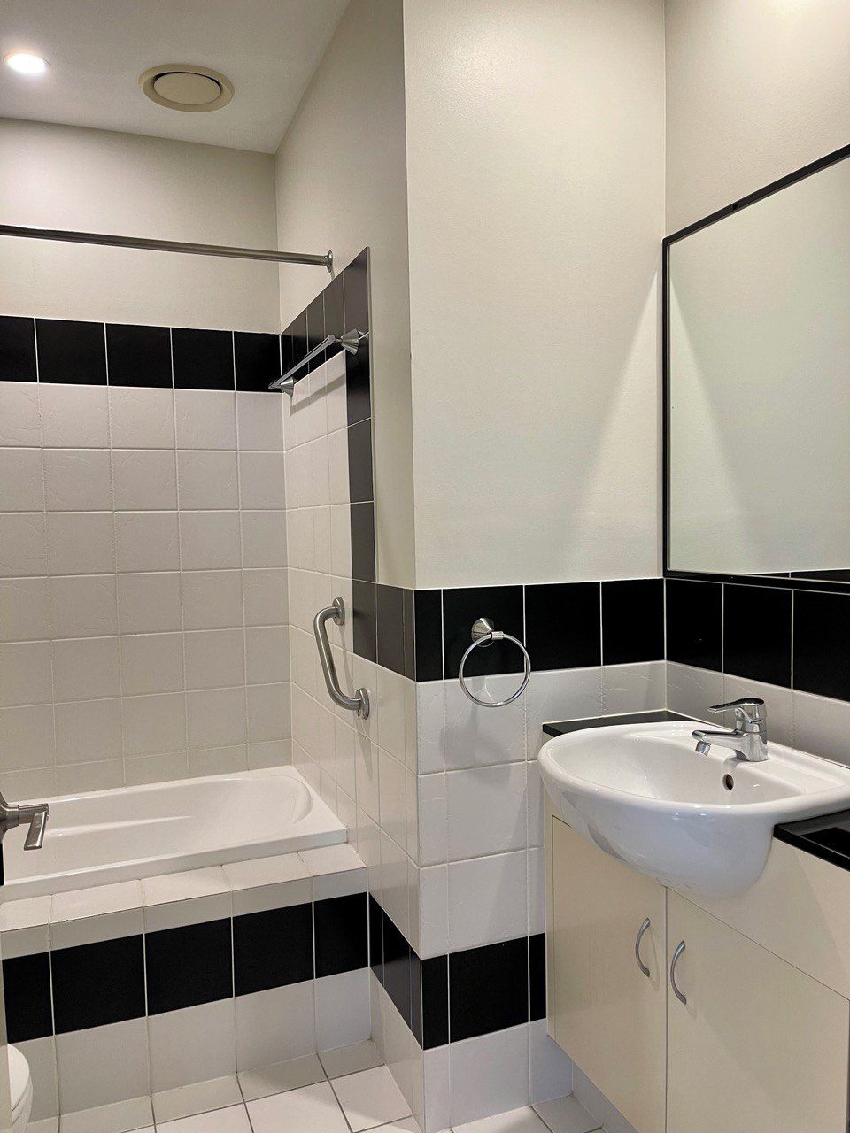 Ein modernes Badezimmer mit Badewanne, Waschbecken und Spiegel.