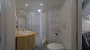 Bathroom features a vanity with a sink, glass shower enclosure, and toilet.