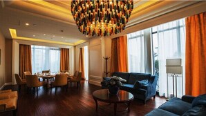 A spacious living area with a dining table, sofas, and a chandelier. - Days Hotel & Suites Sichuan Jiangyou (Mianyang)