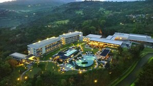 Ein moderner Hotelkomplex mit mehreren Gebäuden, einem Pool und umliegender Bepflanzung.