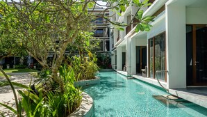 Ein Schwimmbecken, umgeben von üppiger Vegetation und moderner Architektur.