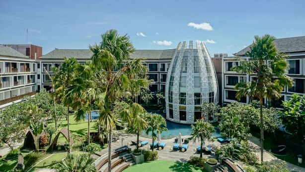 Ein modernes Hotel mit Innenhof, Pool und Sitzbereichen im Freien.