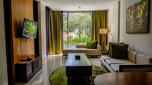 Ein modernes Wohnzimmer mit einer Couch, einem Couchtisch und einem an der Wand montierten Fernseher.