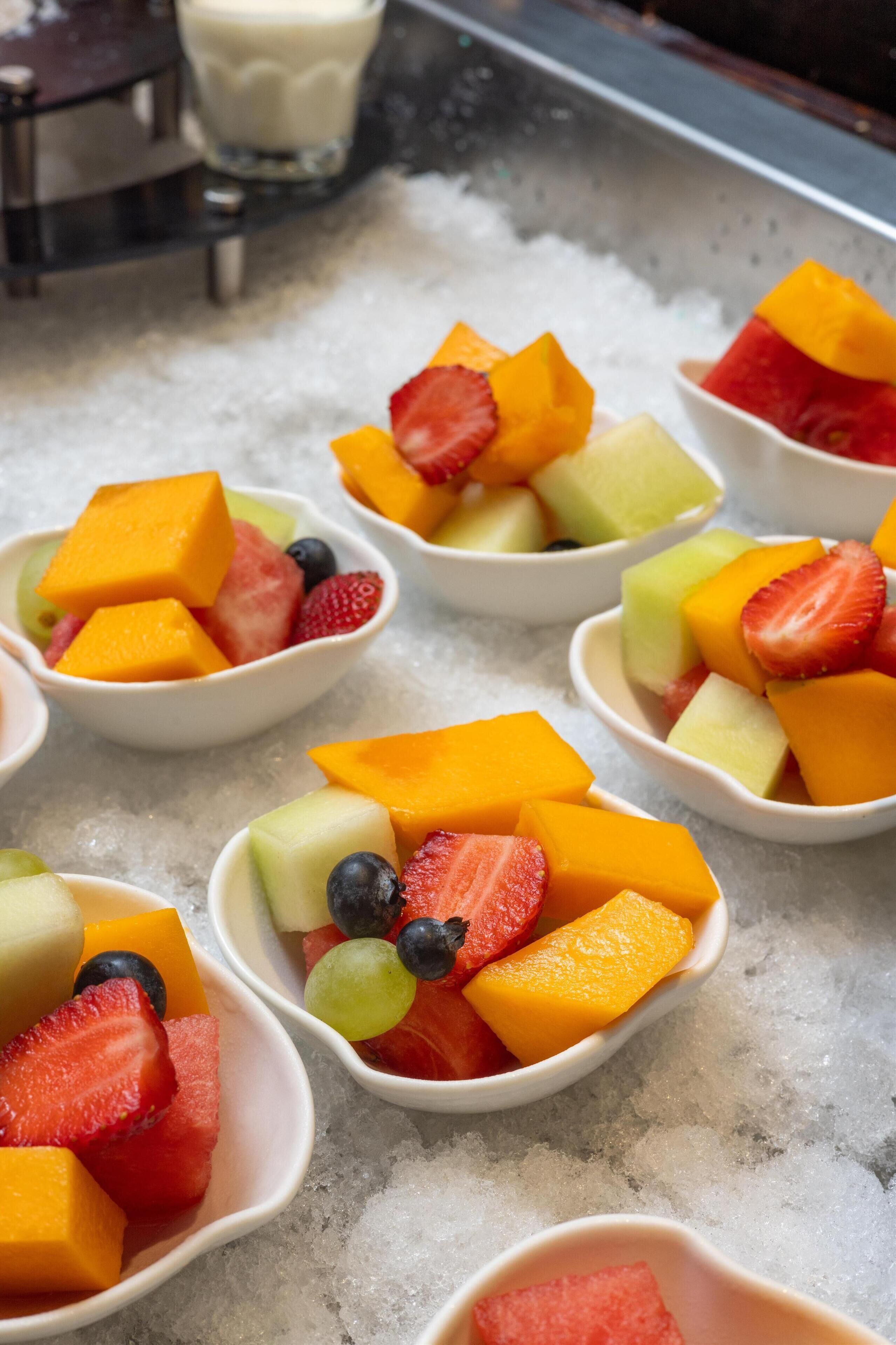 Bowls of fruit on a bed of ice.