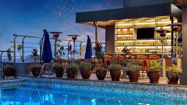Ein Poolbereich auf dem Dach mit Bar und Sitzgelegenheiten.