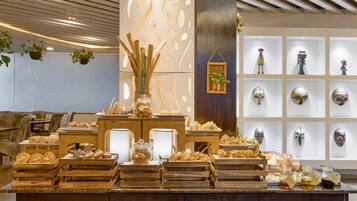 A buffet with various food items and a display of decorative masks.