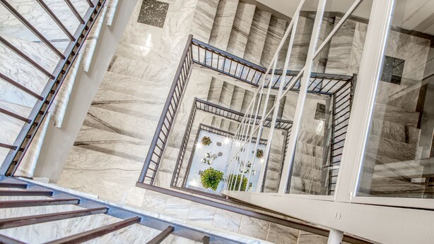 A marble staircase with metal railings and a glass railing on the upper landing. - Gioberti Art Hotel (Rome)