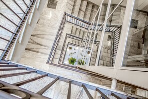 A marble staircase with metal railings and a glass railing on the upper landing. - Gioberti Art Hotel (Rome)