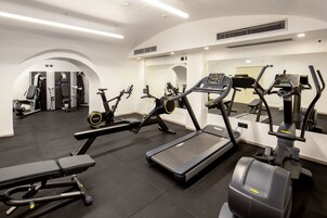 Una palestra moderna con diverse attrezzature per l'allenamento, tra cui tapis roulant, ellittiche e panche per pesi.
