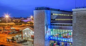 Un edificio moderno con facciata in vetro e un grande cartello illuminato con su scritto "Ronnie's".