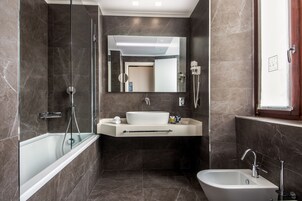 A modern bathroom with a bathtub, a sink, and a shower.