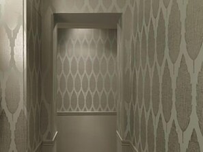 A narrow hallway with patterned walls and a door at the end. - Paradise Hotel (Paris)