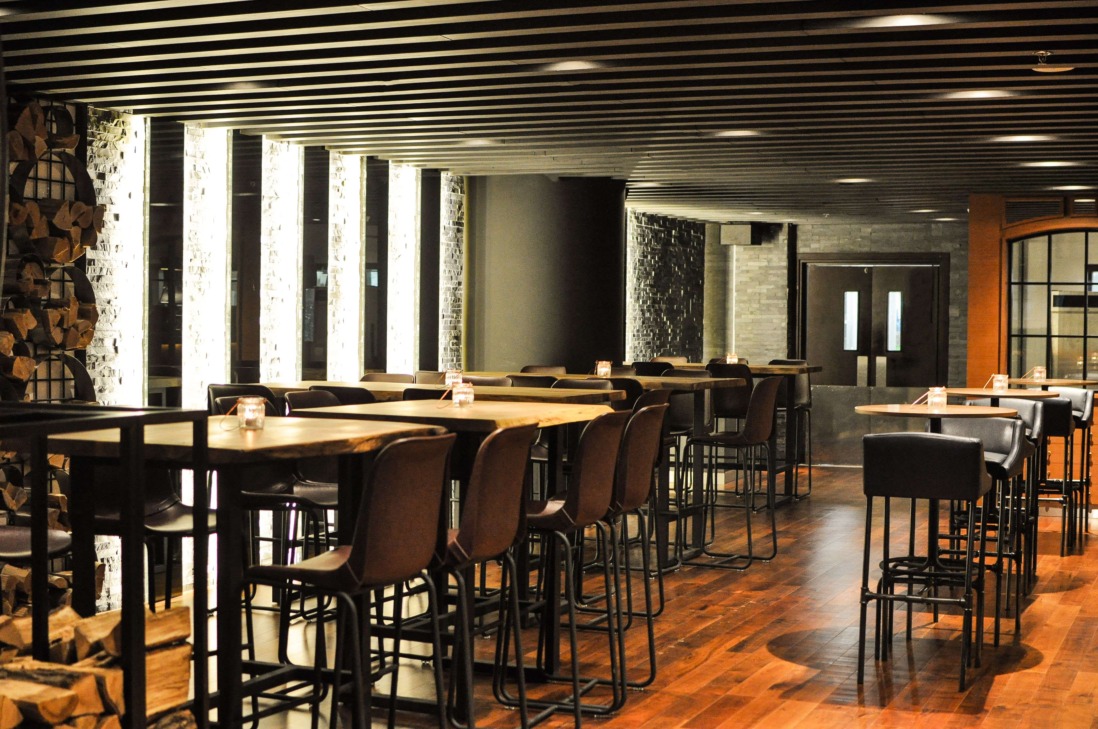 Un restaurante con mesas y sillas de madera, una pared de piedra y una pared de ladrillo.