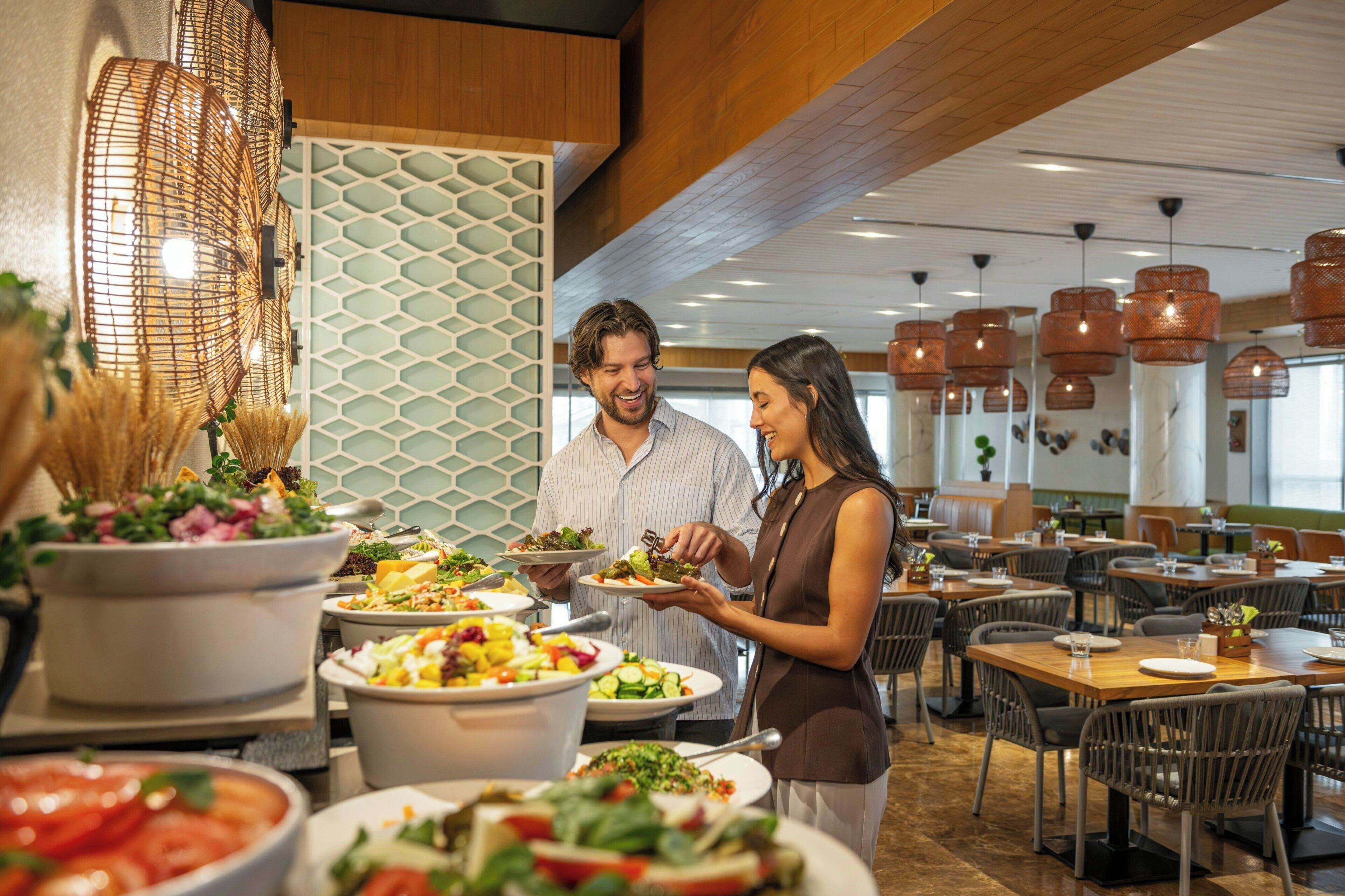 Un ristorante con diversi tavoli, una varietà di piatti in mostra e lampade a sospensione.