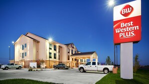 A hotel with a 'Best Western Plus' sign, multiple floors, and a parking lot with several vehicles. - Best Western Plus Stevens County Inn (Hugoton)
