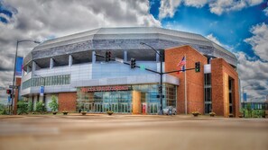 A modern stadium with a glass facade, a prominent entrance, and an American flag. - Staybridge Suites Des Moines Downtown by IHG (Des Moines)
