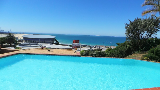 A swimming pool with a view of the ocean and a beach. - The Chapman Hotel & Conference Centre (Gqeberha (Port Elizabeth))