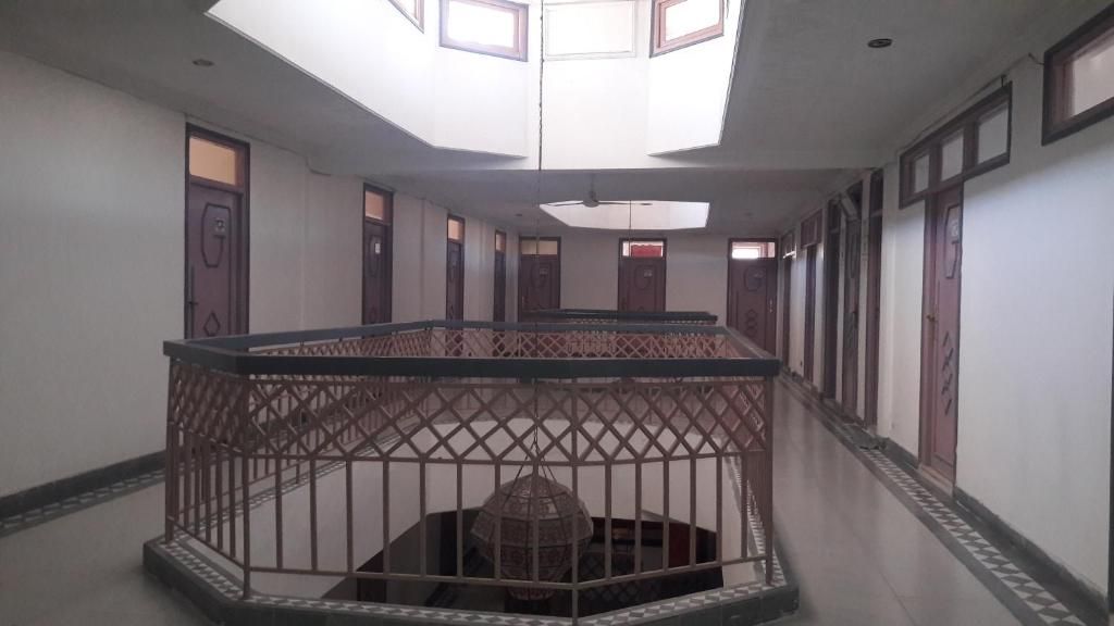 Un intérieur à plusieurs niveaux, doté d’un escalier en colimaçon central, d’une verrière et d’un sol à motifs.