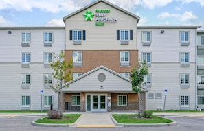 A multi-story hotel with a central entrance, a green logo, and a brick facade. - Extended Stay America Select Suites - Clearwater (Clearwater)