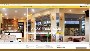 A hotel reception area with a modern design, a reception desk, and a seating area. - Quan Quan Hotel (Da Nang)