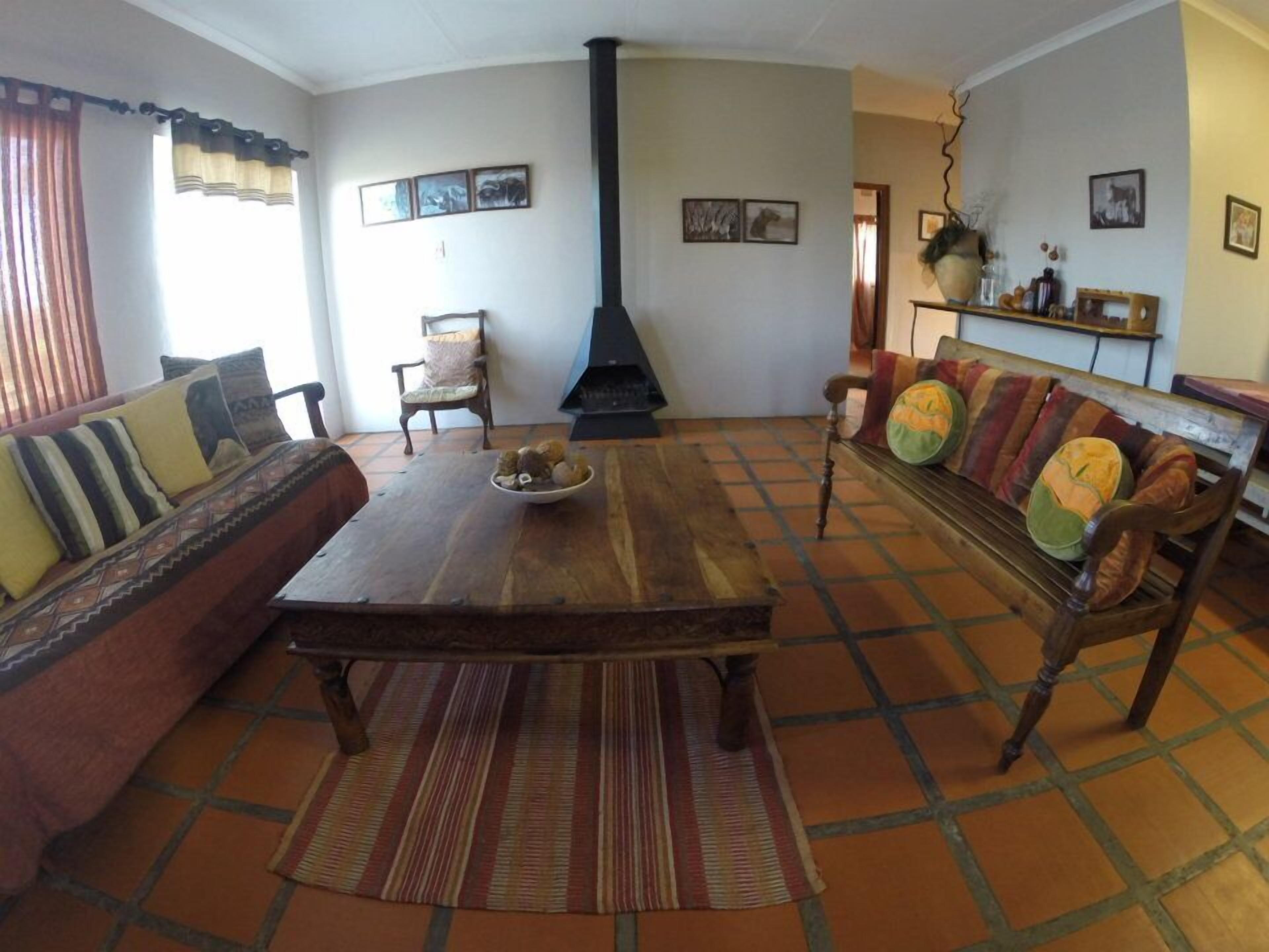 Una sala de estar con un sofá, una mesa de centro de madera, un tapete estampado y una chimenea.