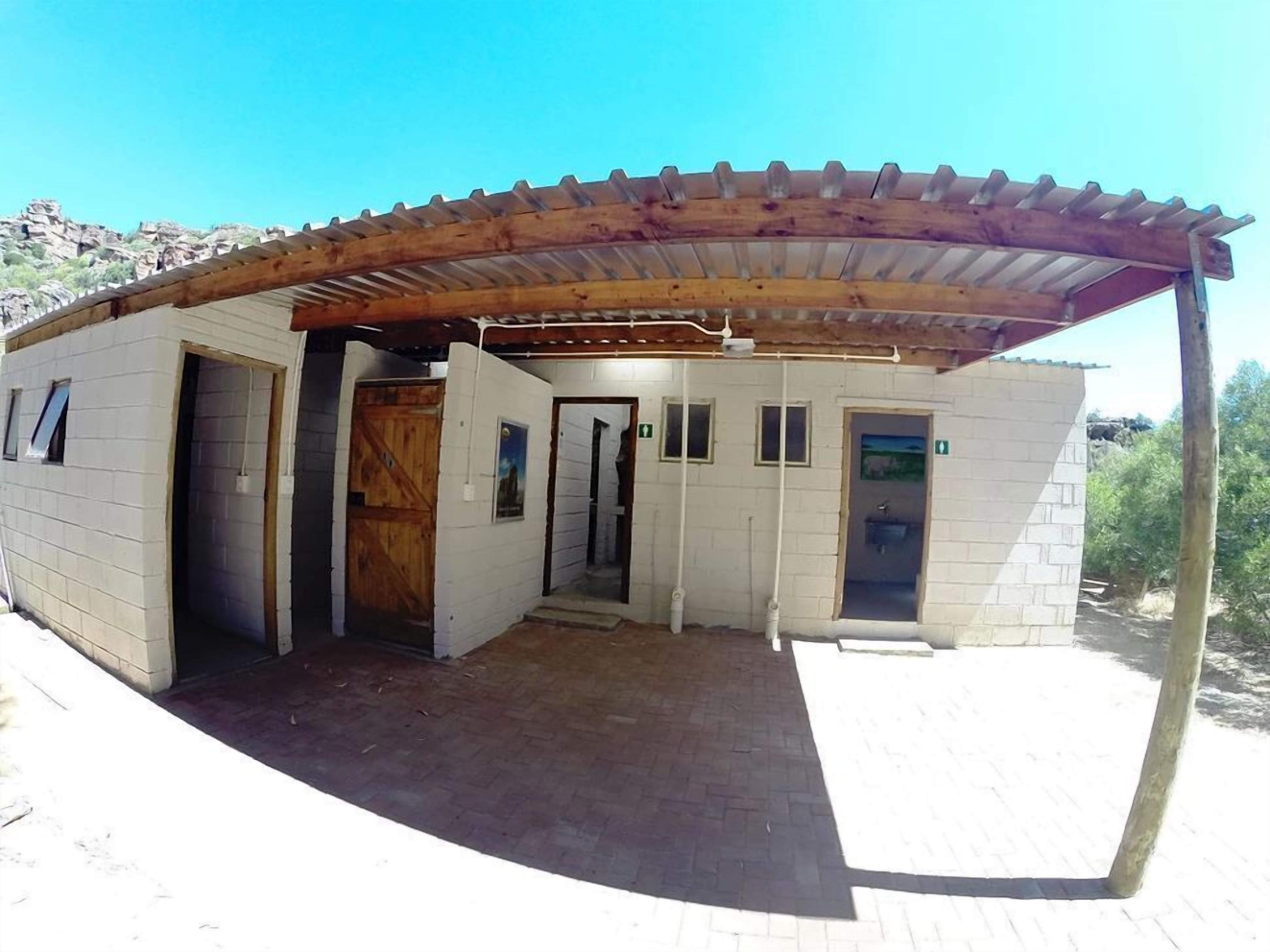 A small building with a covered entrance, multiple doors, and a brick exterior.