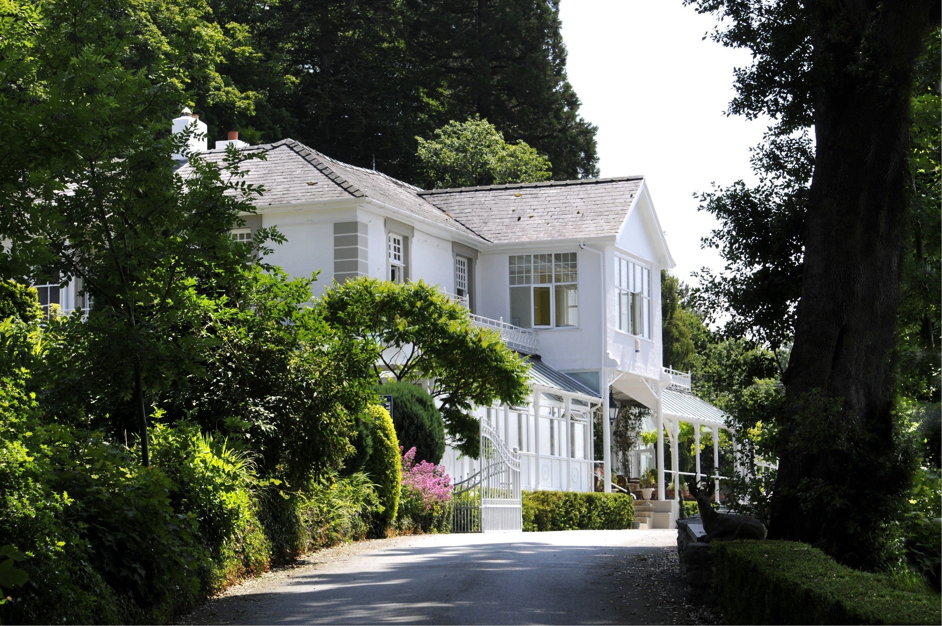 A white two-story house with a covered porch and a driveway.