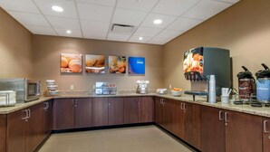 A modern kitchen area with a coffee station, a microwave, and a display of breakfast items. - Comfort Inn PA Turnpike - 1-81 (Carlisle)