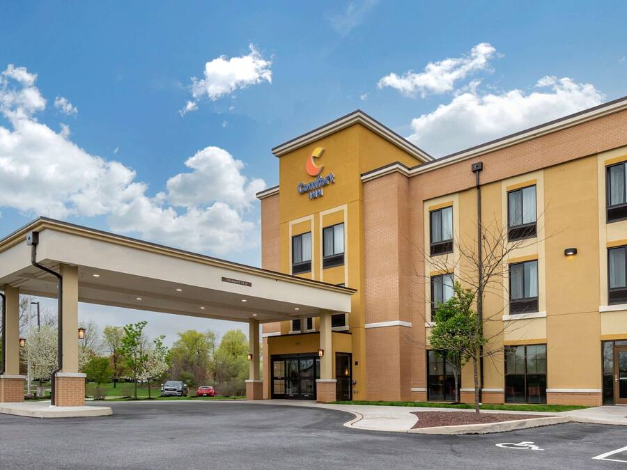 Un hotel Comfort Inn con estacionamiento cubierto, varios pisos y cielo despejado.