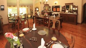 A dining area with a round table set for four, surrounded by wooden chairs.