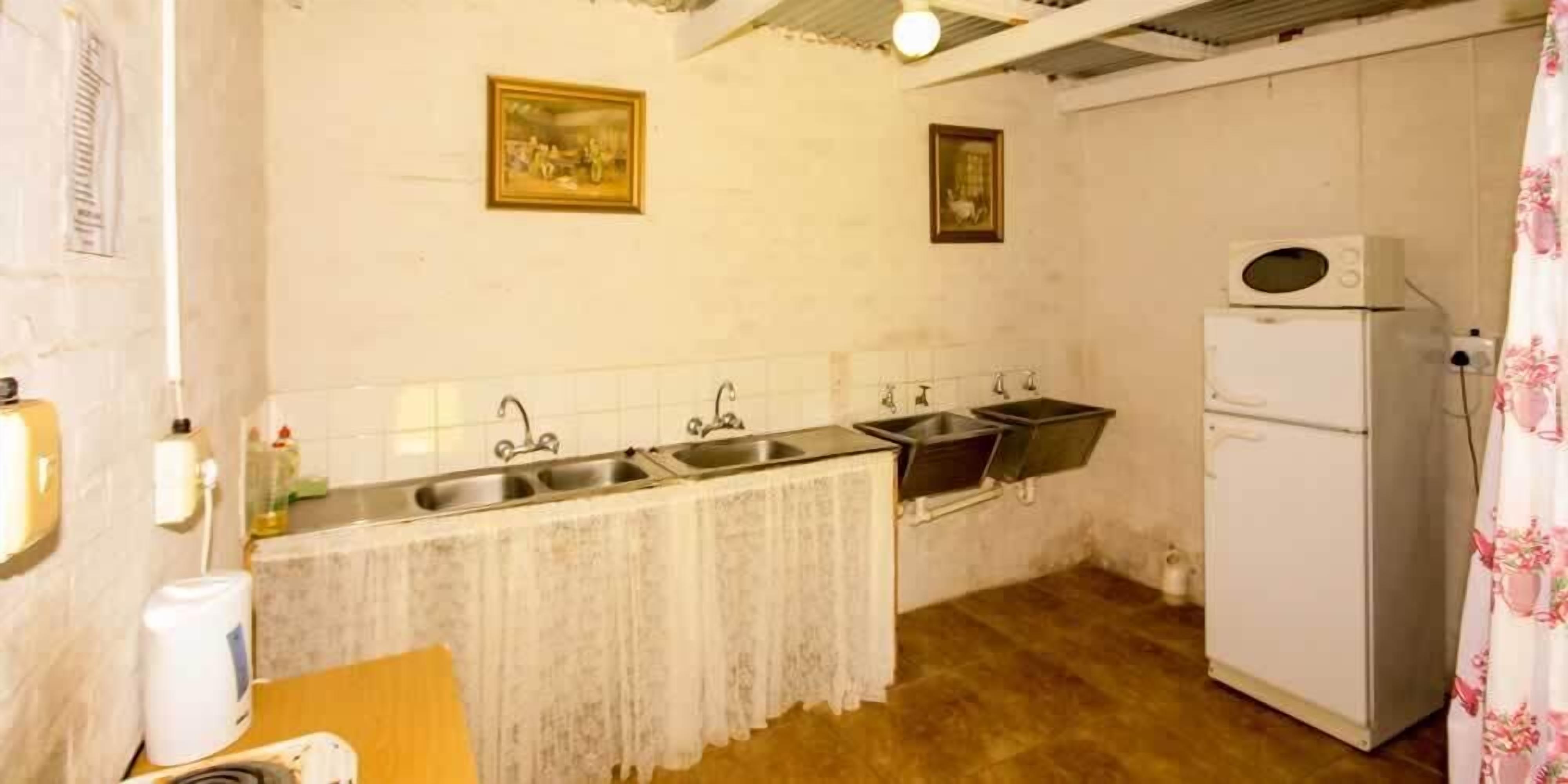 Una cocina compacta con refrigerador, pileta y microondas.