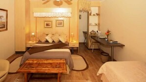 A hotel room with a bed, a desk, a chair, and a small table. - Homestead B & B (Addo)