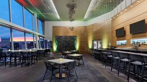 Eine moderne Bar mit Sitzgelegenheiten und Blick auf die Stadt.