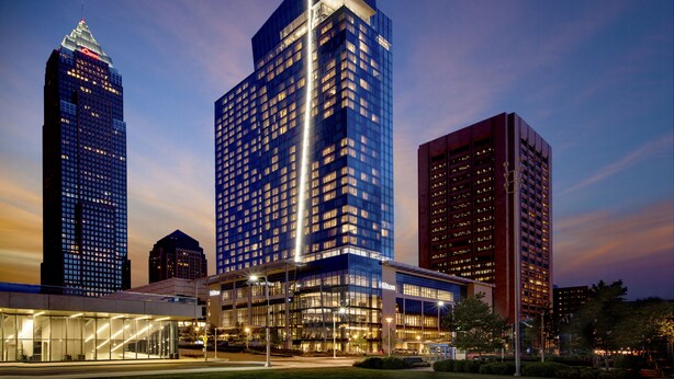 A modern hotel with a prominent 'Hilton' sign, surrounded by other high-rise buildings. - Hilton Cleveland Downtown (Cleveland)