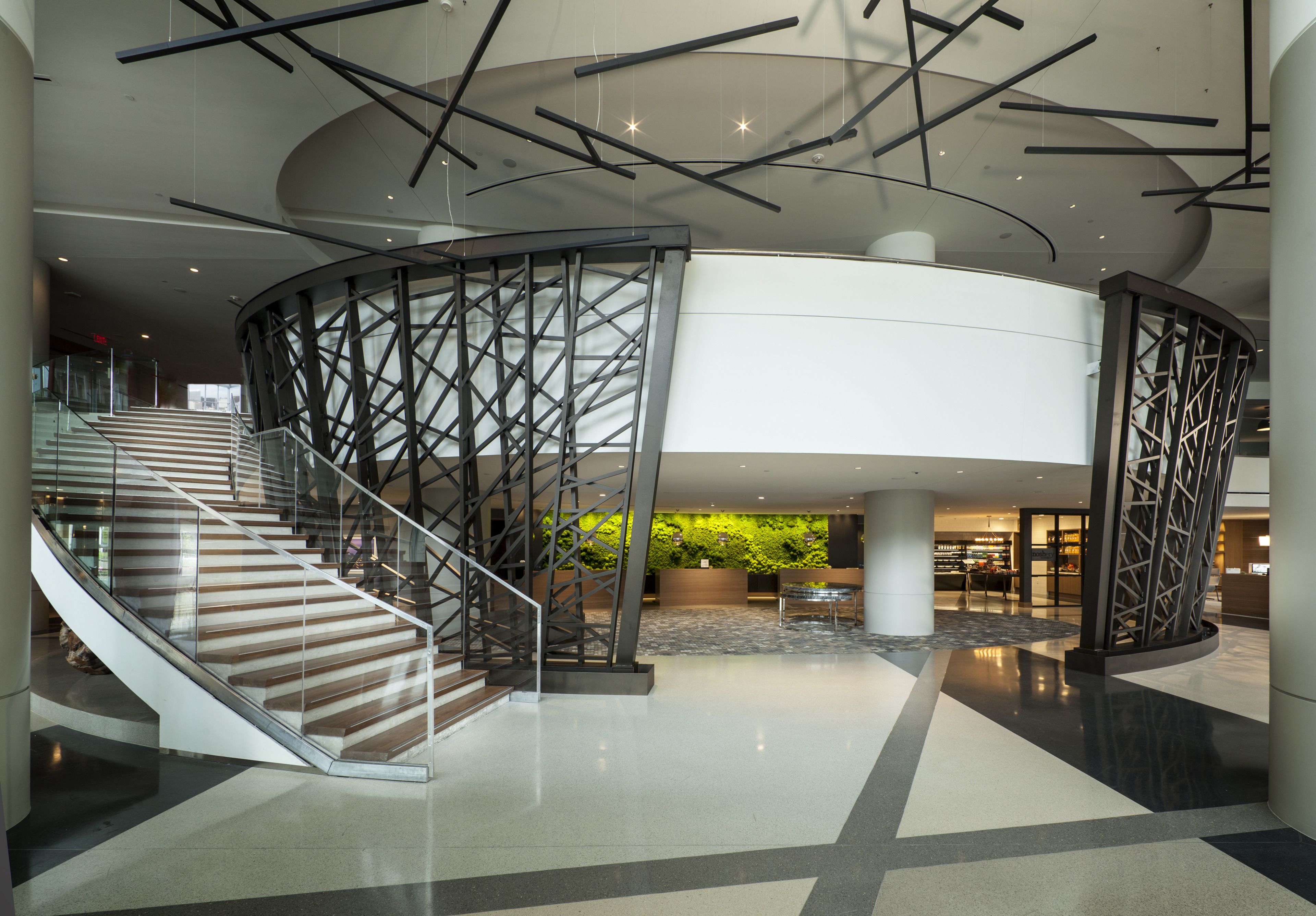 A modern interior with a central staircase, a reception area, and a curved ceiling design.