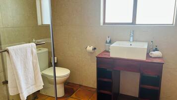 A bathroom with a toilet, sink, and a towel rack.