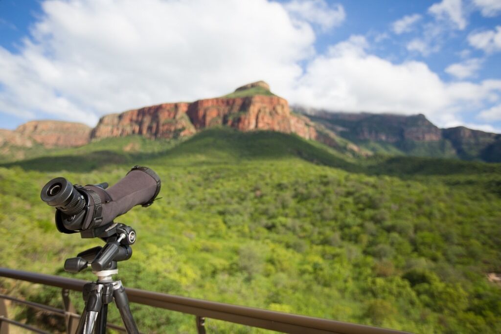 Un telescopio sobre trípode con vistas a un paisaje montañoso.