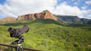Un telescopio sobre trípode con vistas a un paisaje montañoso.