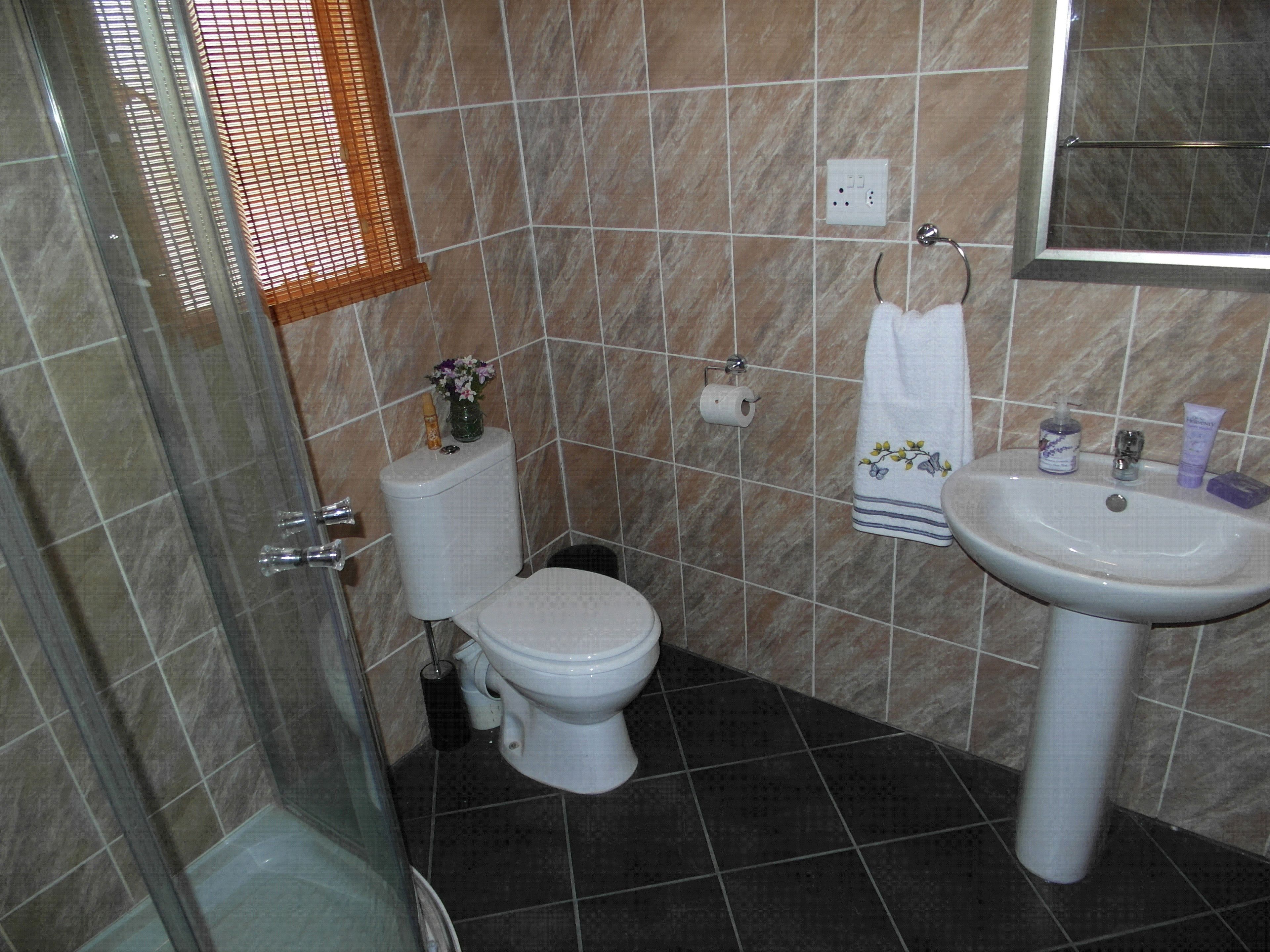 A bathroom with a toilet, sink, and shower.