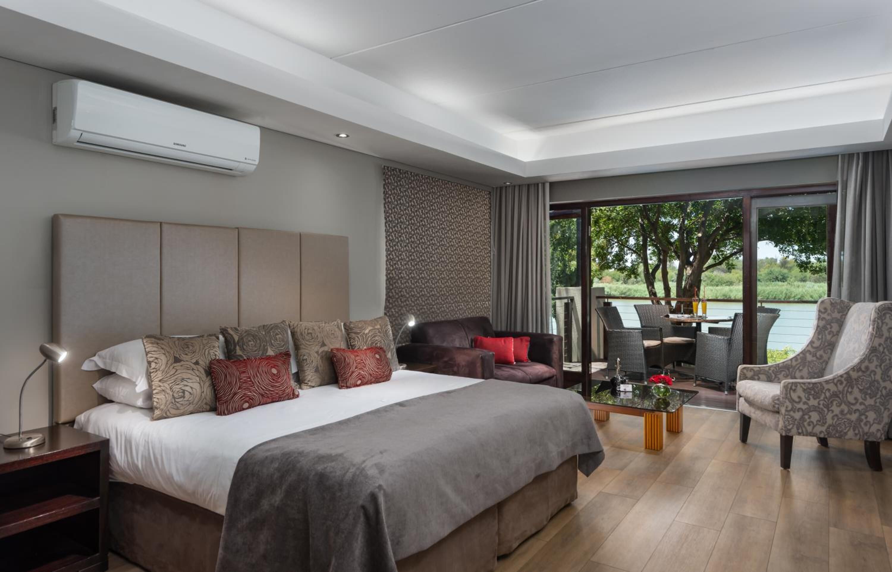 Una habitación de hotel moderna con una cama grande, un escritorio y vistas al exterior.