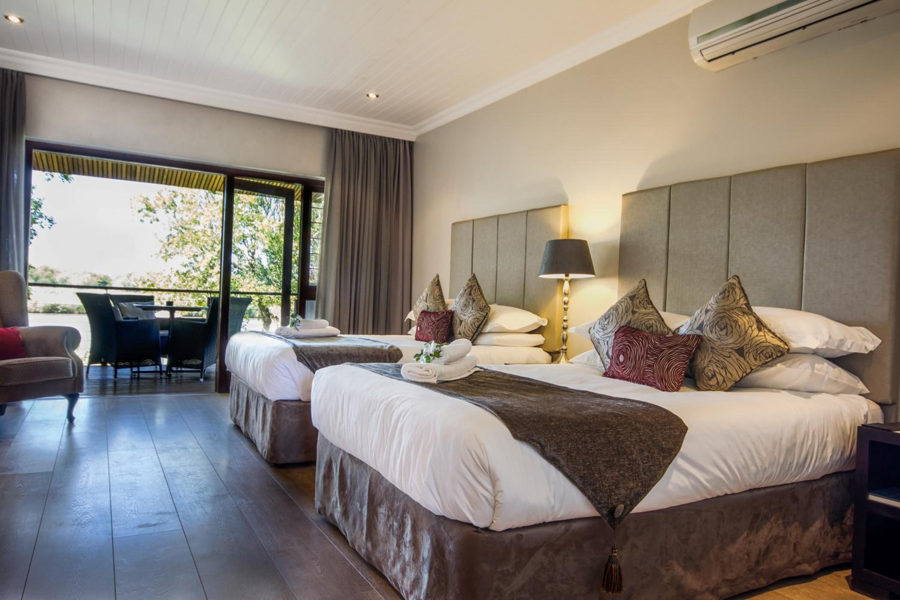 Une chambre d’hôtel avec deux lits, un bureau et une chaise.