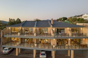 A multi-story building with a flat roof, large windows, and outdoor seating areas. - Overmeer Guest House (Knysna)