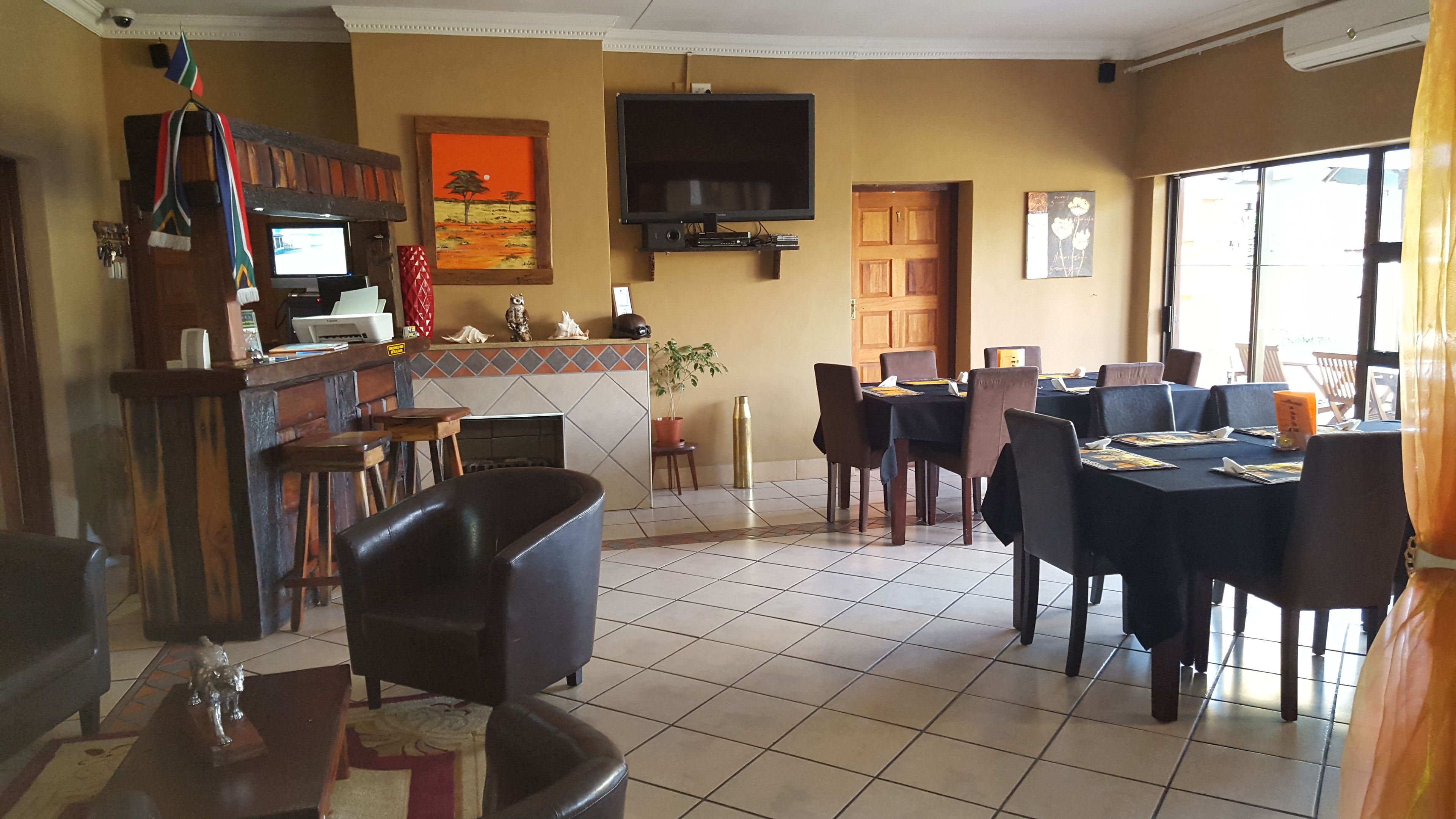 A restaurant with a bar area, dining tables, and chairs.