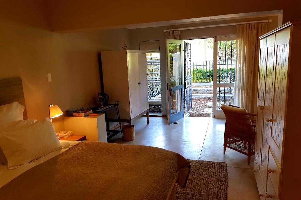 A hotel room with a bed, a desk, a chair, and a wardrobe.