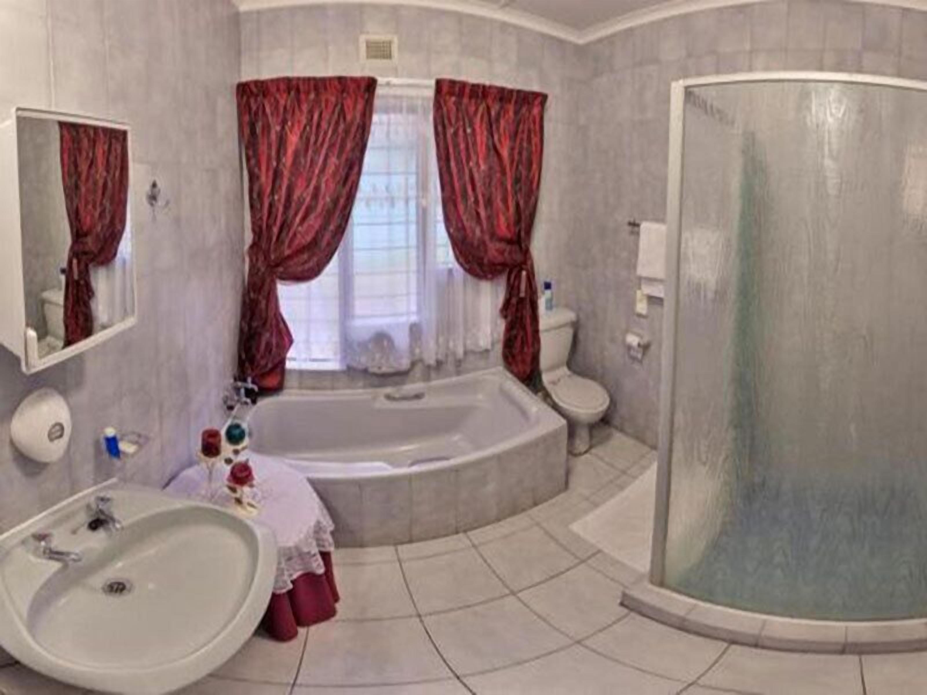 A bathroom with a bathtub, toilet, and sink.